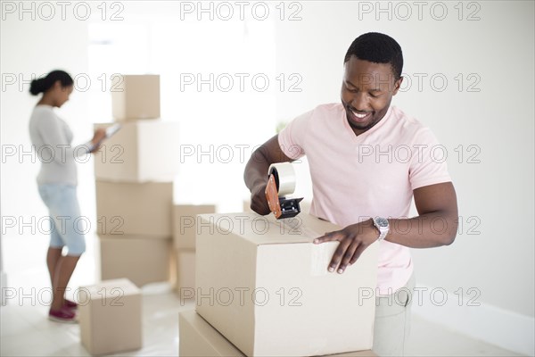 Man taping cardboard box to move