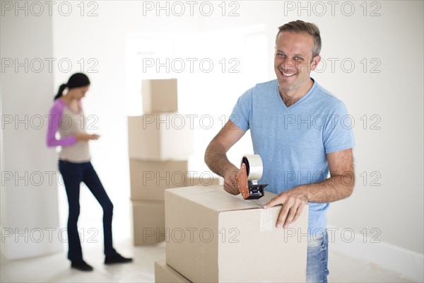 Man taping cardboard box to move