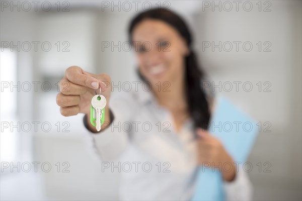 Mixed race realtor holding keys to new home