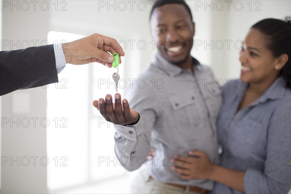 Realtor giving couple keys to new home