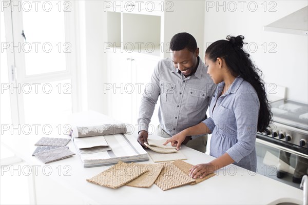 Couple examining fabric swatches in new home