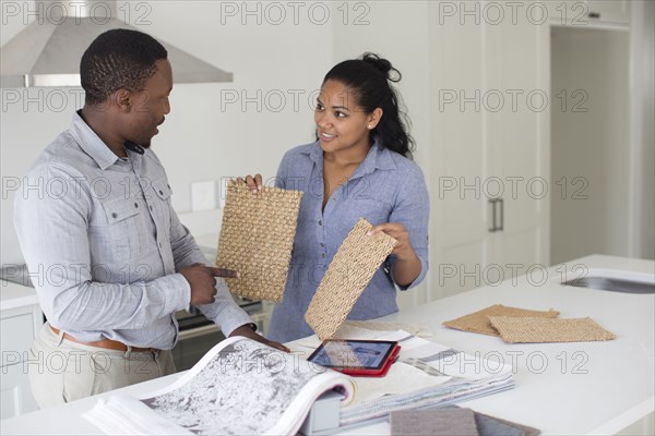 Couple examining fabric swatches in new home