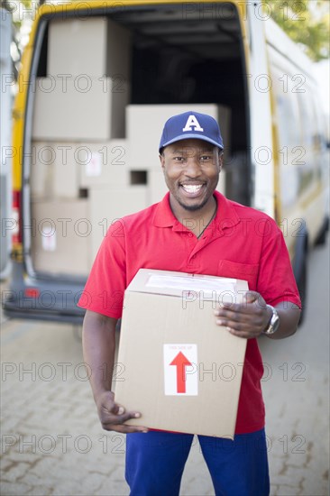 Black delivery man holding package