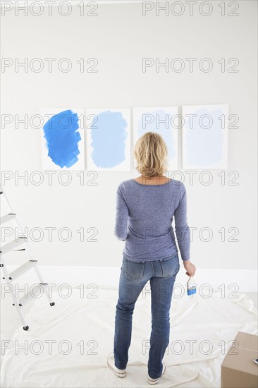 Caucasian woman examining paint samples in new home