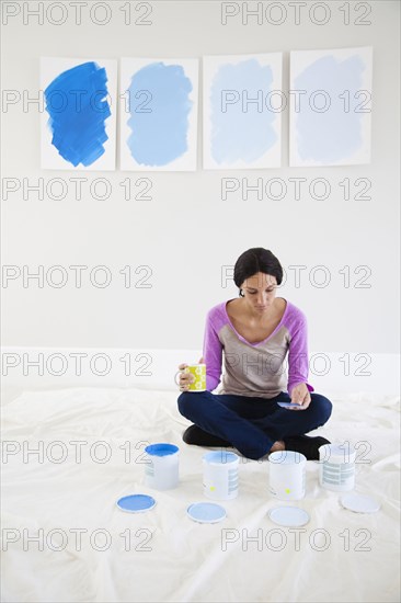 Mixed race woman examining paint samples in new home