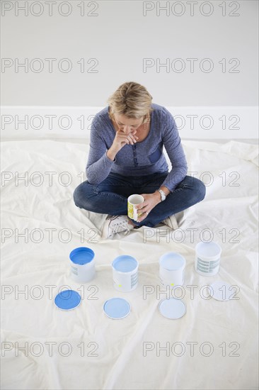 Caucasian woman examining paint samples in new home