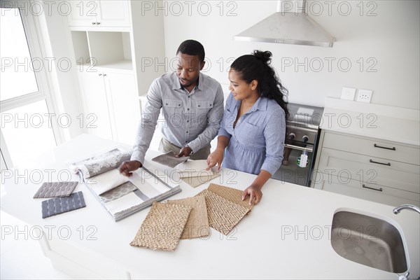 Couple examining fabric swatches in new home