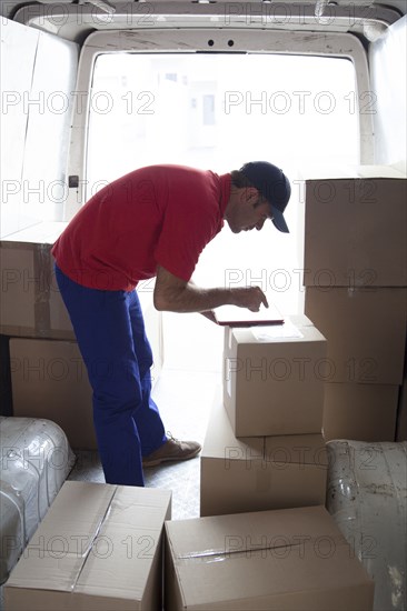 Caucasian delivery man using digital tablet in van