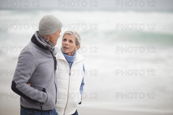 Caucasian couple walking on beach