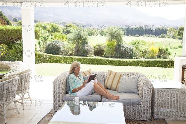 Caucasian woman using digital tablet on sofa