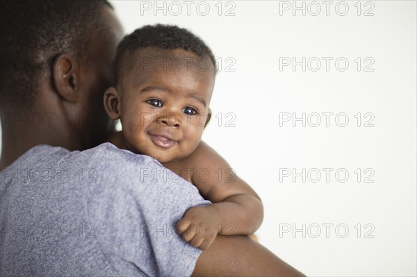 Close up of Black father carrying baby