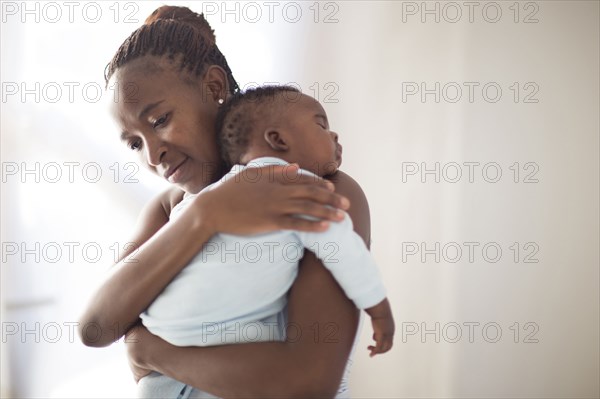 Black mother holding sleeping baby