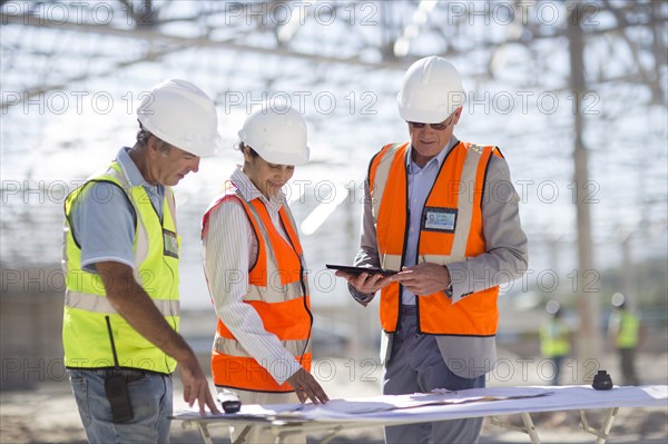 Architects reading blueprints at construction site