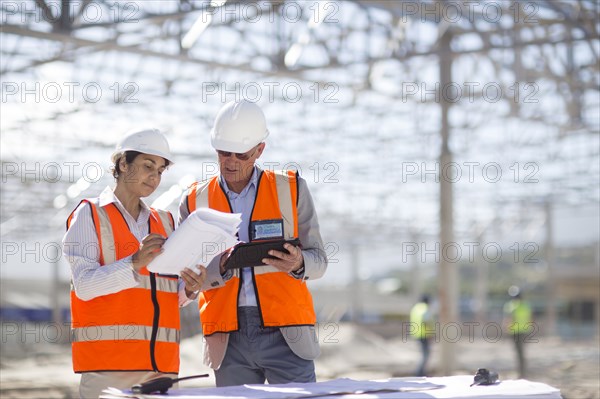 Architects reading blueprints at construction site