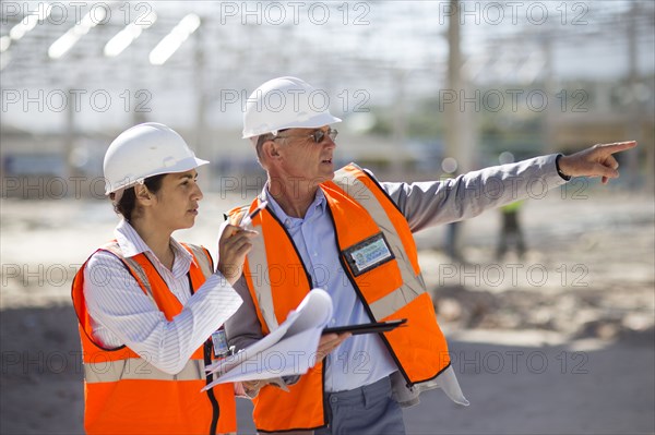 Architects reading blueprints at construction site