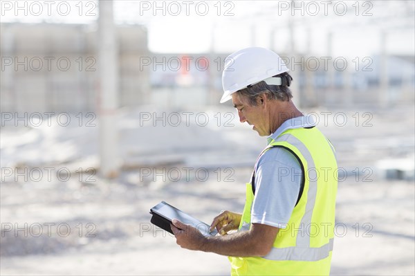 Caucasian architect using digital tablet at construction site