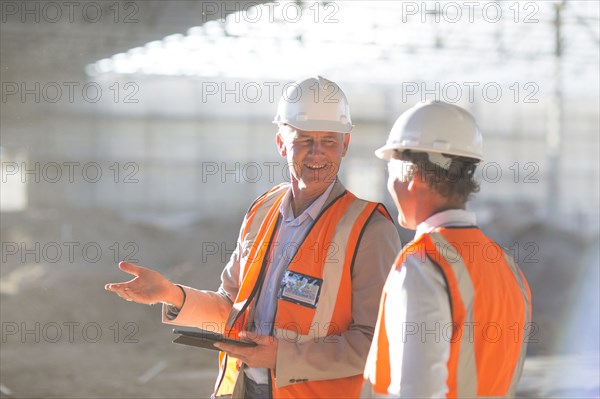 Caucasian architects using digital tablet at construction site