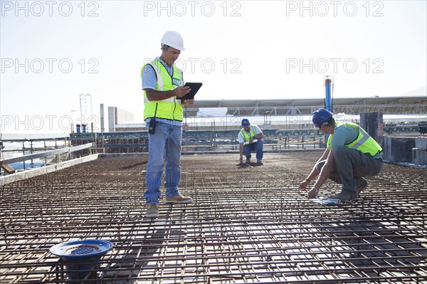 Construction workers arranging rebar at construction site