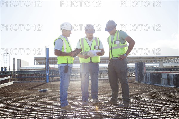 Construction workers talking on rebar at construction site