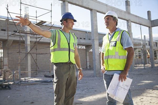 Caucasian construction workers talking at construction site