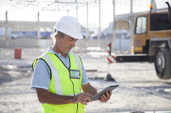 Caucasian construction worker using digital tablet at construction site