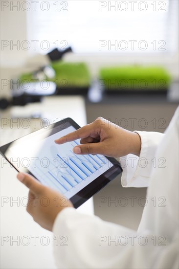 Mixed race scientist using digital tablet in laboratory