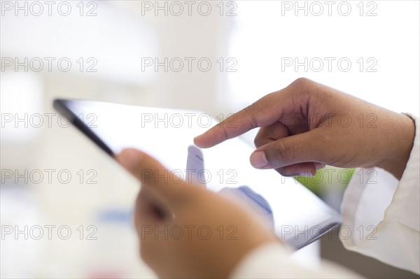 Mixed race scientist using digital tablet in laboratory