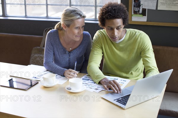 Business people using laptop in office meeting