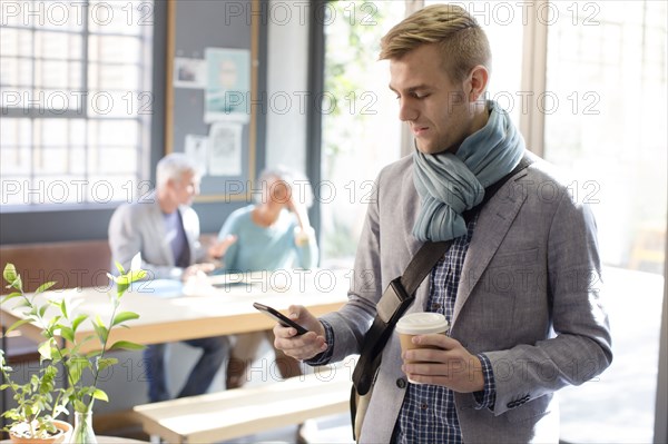 Businessman using cell phone in office