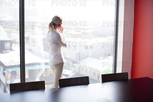 Caucasian businesswoman talking on cell phone in conference room