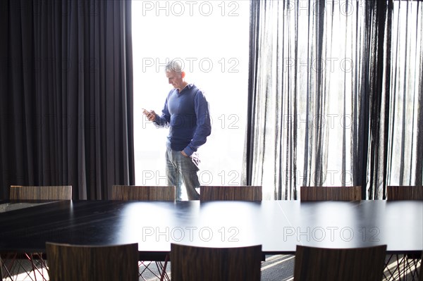 Caucasian businessman using cell phone in conference room