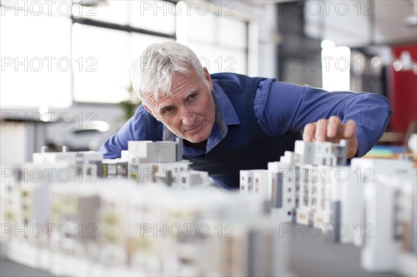 Caucasian architect examining architectural model in office