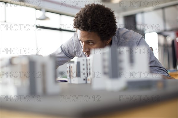 Mixed race architect examining architectural model in office