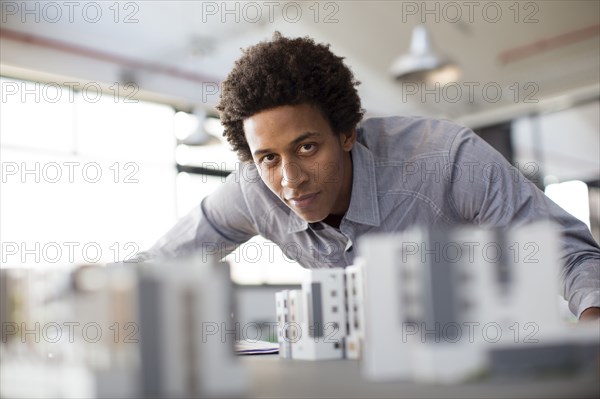 Mixed race architect examining architectural model in office