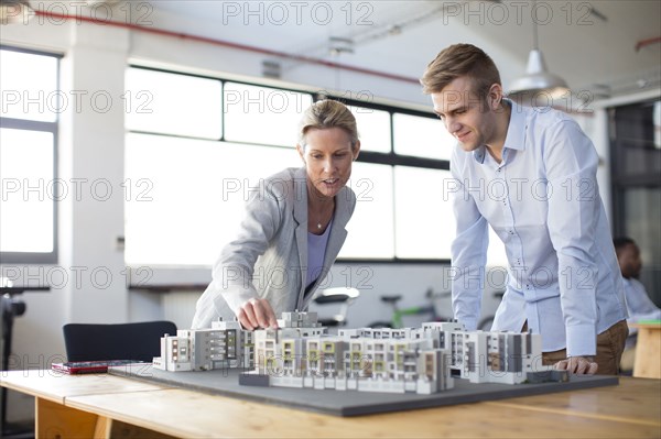 Caucasian architects examining architectural model in office