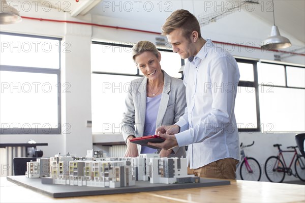 Caucasian architects examining architectural model in office