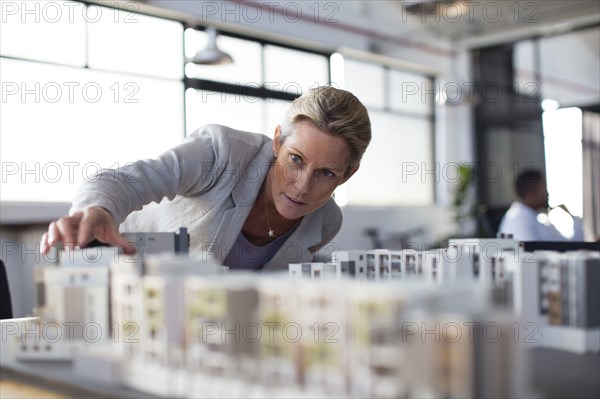 Caucasian architect examining architectural model in office