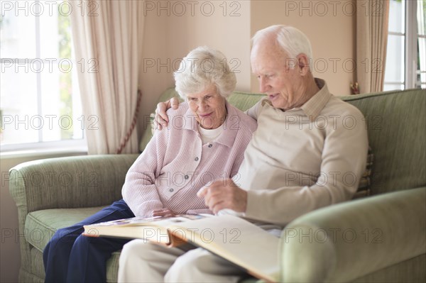 Older Caucasian couple looking at photo album