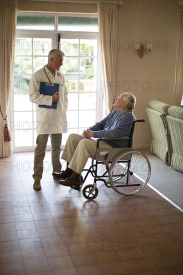 Doctor talking to patient in wheelchair