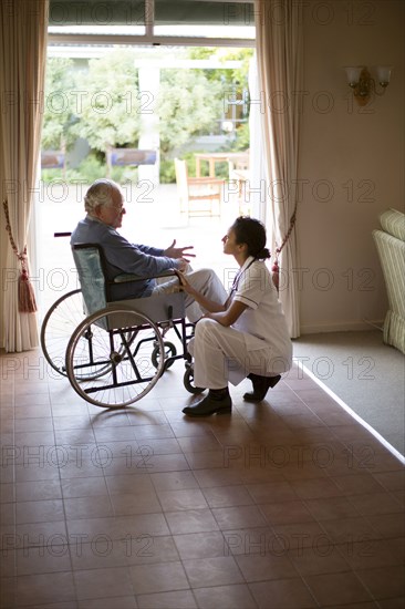 Nurse talking to patient in wheelchair