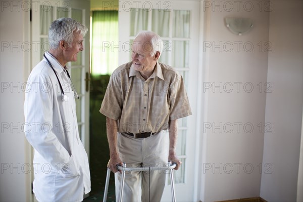 Doctor talking to patient using walker