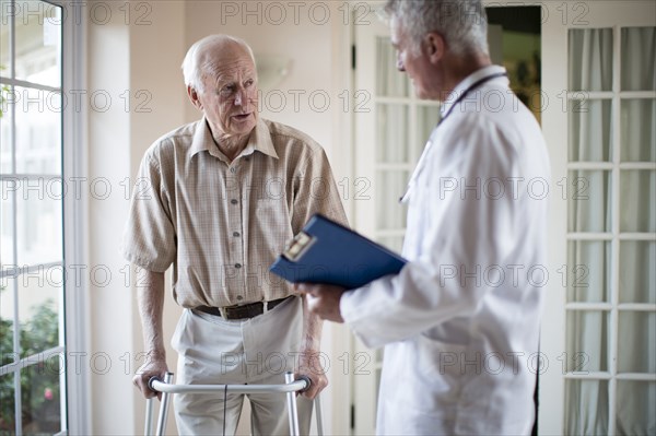 Doctor talking to patient using walker