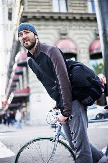 Caucasian man riding bicycle in city