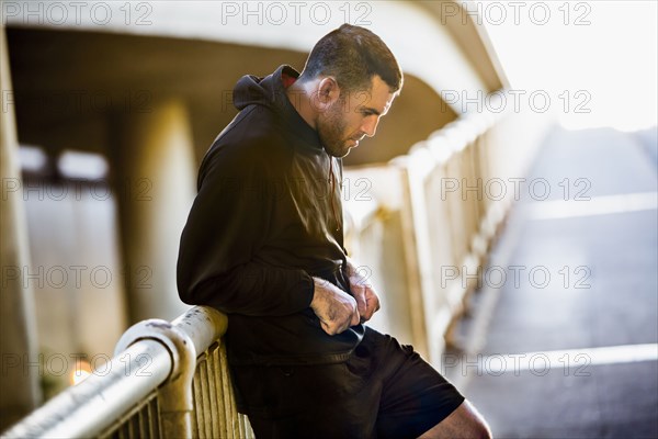 Caucasian man resting on railing