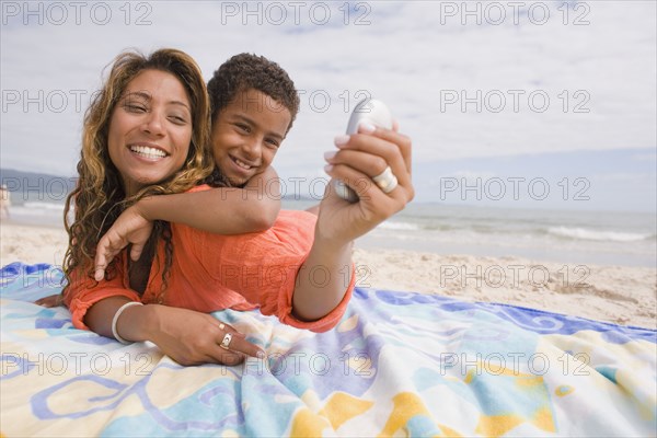 Mother and son taking self portrait on the beach