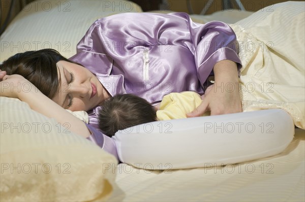 Woman sleeping with newborn baby