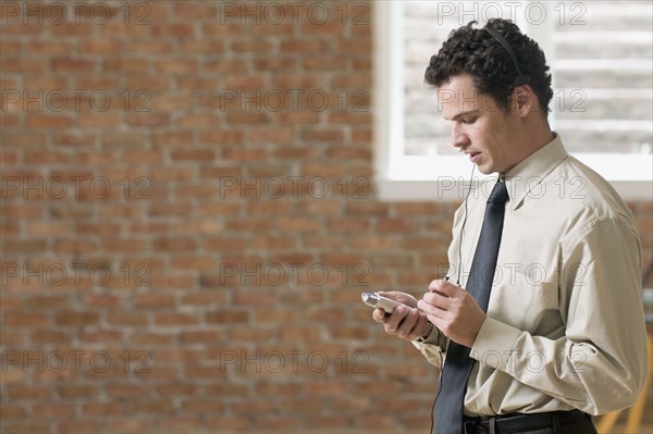 Businessman using PDA with head set