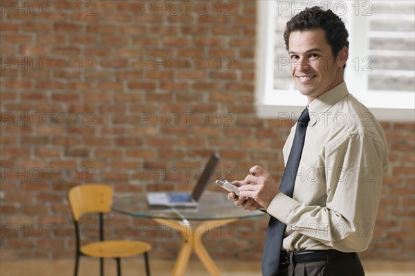 Businessman using PDA indoors