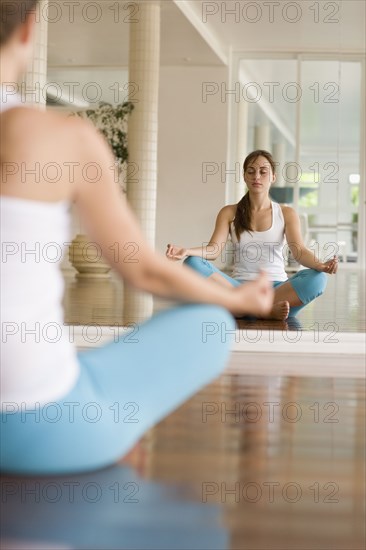 Hispanic woman meditating at health club