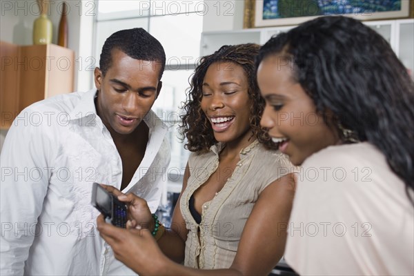 Multi-ethnic men and women looking at cell phone